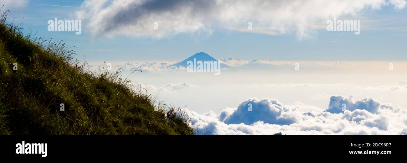 Paysage panoramique photo du Mont Agung, le plus haut volcan de Bali, s'élevant au-dessus des nuages depuis le camping le premier jour des trois jours Mont Rinjani Trek, Lombok, Indonésie, Asie, arrière-plan avec espace de copie Banque D'Images