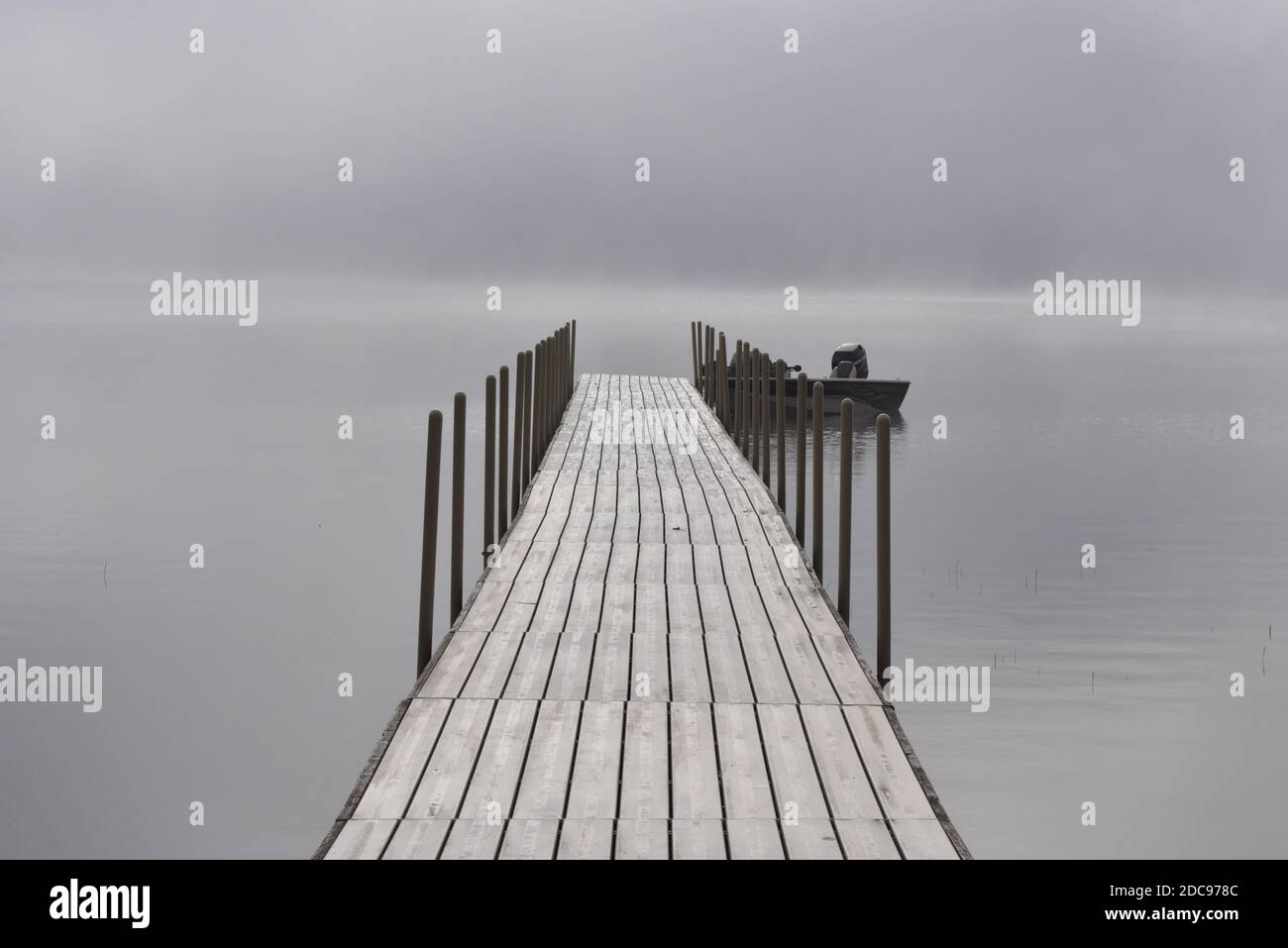 quai de pêche vide sur le lac sur un brouillard matin en été Banque D'Images