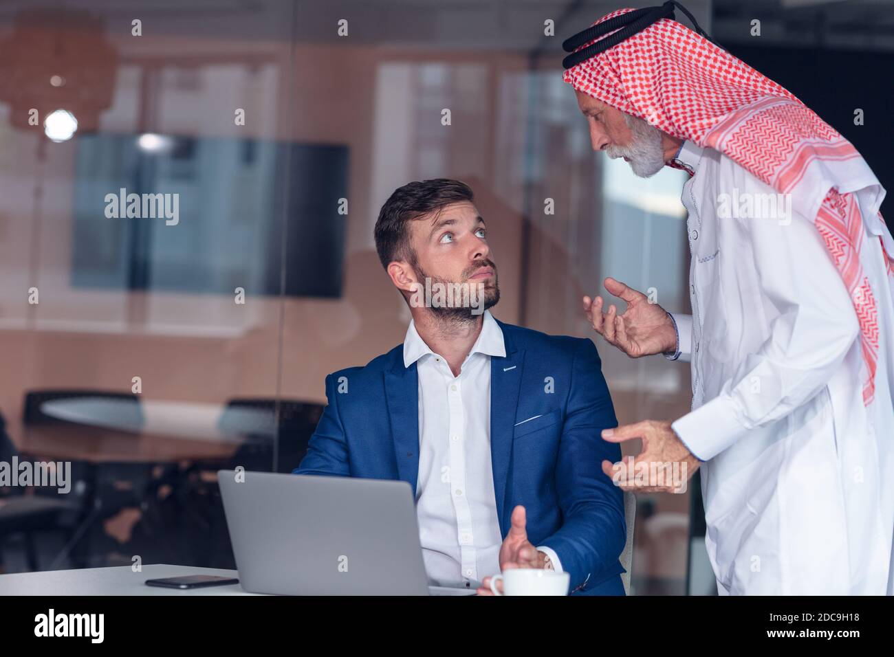 Homme d'affaires du Moyen-Orient mature portant le ghoutra lors d'une réunion Banque D'Images