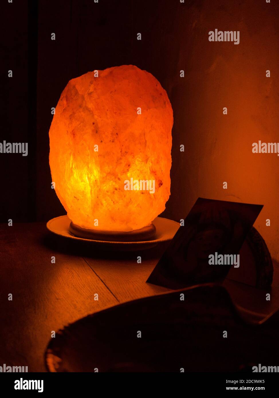 lampe à sel orange allumée sur une étagère en bois Banque D'Images