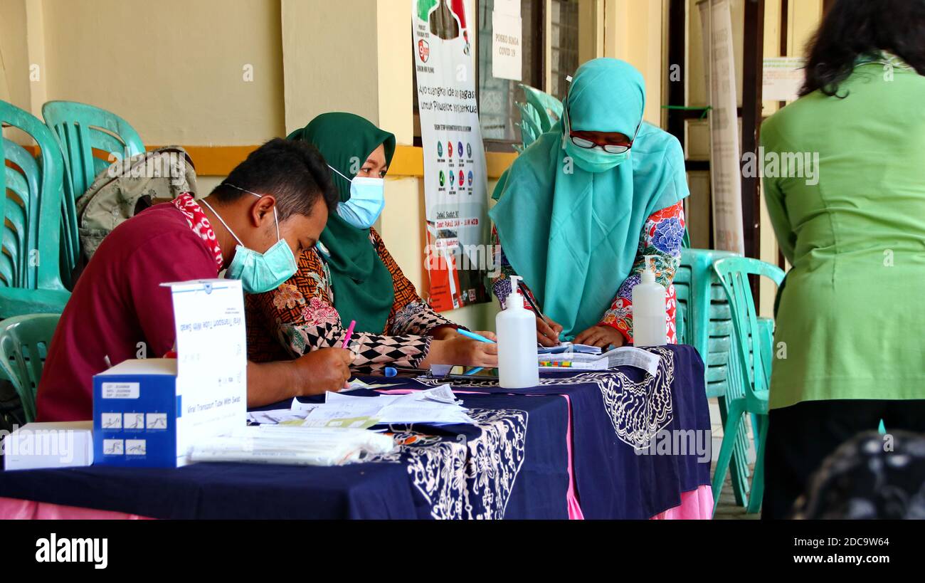 Médecin en costume de protection prenant un écouvillon nasal d'une personne pour tester une éventuelle infection à coronavirus, Pekalonga, Indonésie, 19 novembre 2020 Banque D'Images
