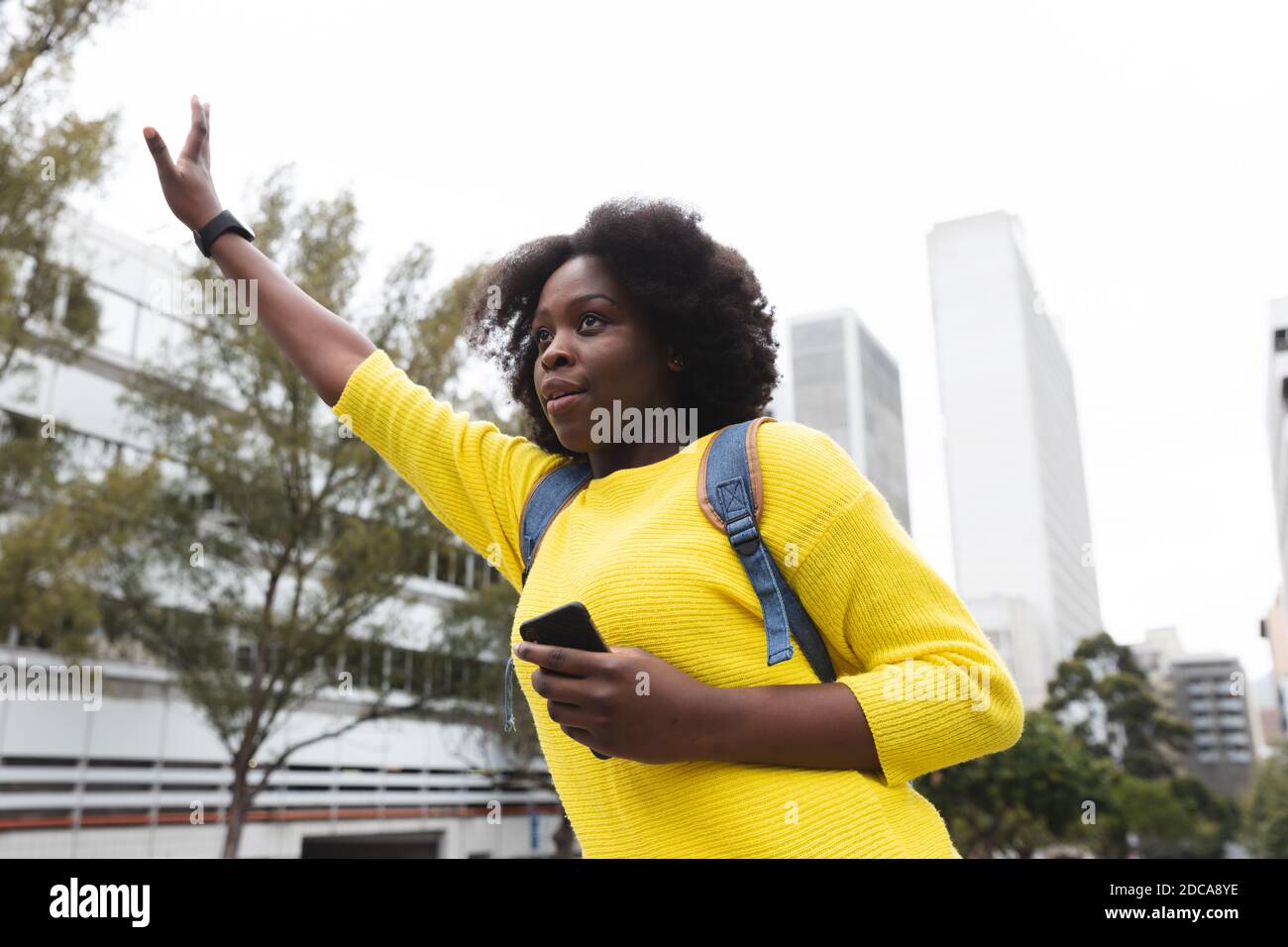 Femme afro-américaine utilisant un smartphone dans une rue Banque D'Images