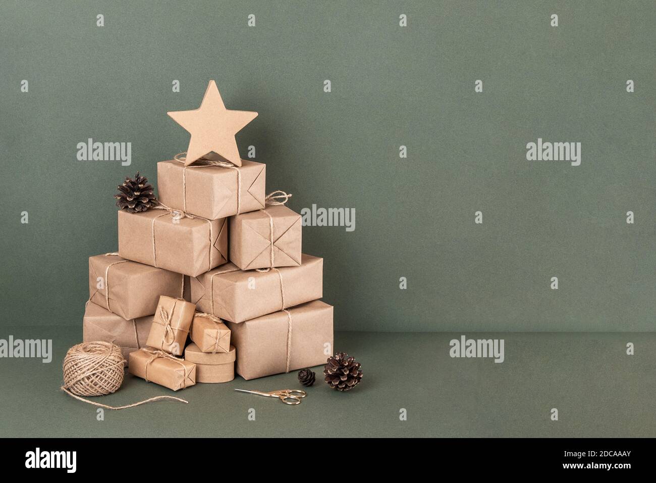 Arbre de Noël abstrait. Boîtes en papier d'artisanat, ficelle, ciseaux, cônes sur fond vert, gros plan. Concept NOËL ou vacances du nouvel an. Copie de la vue de face Banque D'Images