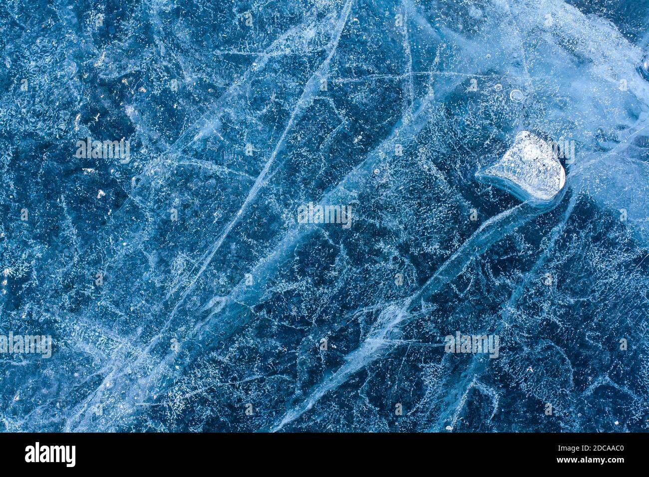 Une incroyable structure de glace avec des fissures et des bulles d'air. Peu de glace fondue sur de la glace bleue. Motif hiver. Horizontale. Banque D'Images