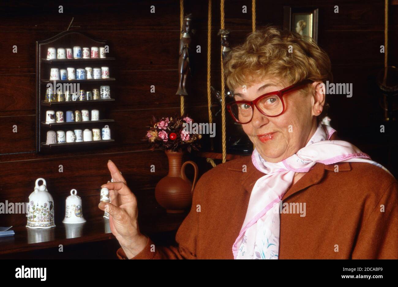 Johanna König, deutsche Sauspielerin und ehemalige Werbefigur, präsenoert ihre Fingerhut-Sammlung zu Hause in Berlin, Allemagne 1988. Banque D'Images
