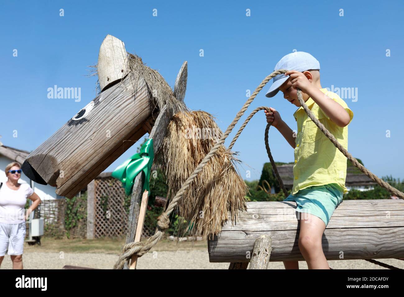 Portrait de l'enfant assis sur un cheval en bois Banque D'Images