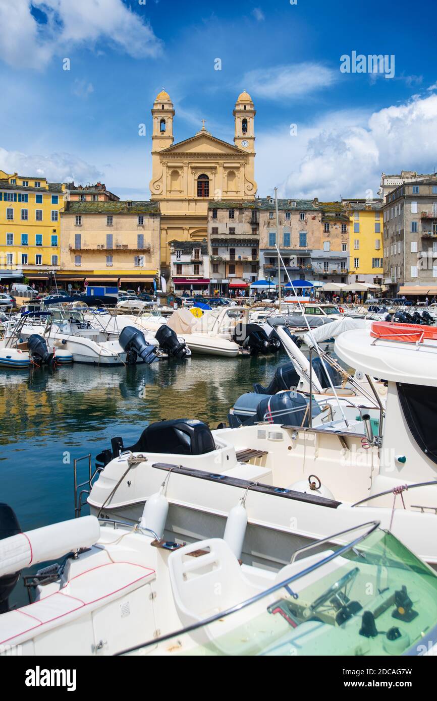 Vue sur l'église Saint-Jean-Baptiste à Bastia depuis le vieux port avec quelques bateaux reposant dans le port pendant l'été Banque D'Images