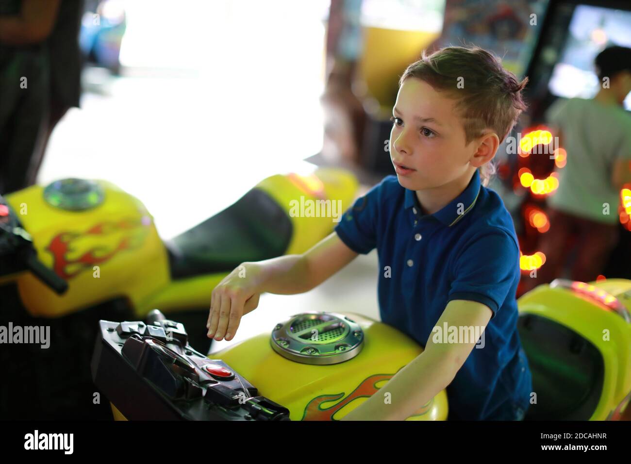 Enfants jouant au simulateur de moto dans le centre d'attractions Photo  Stock - Alamy