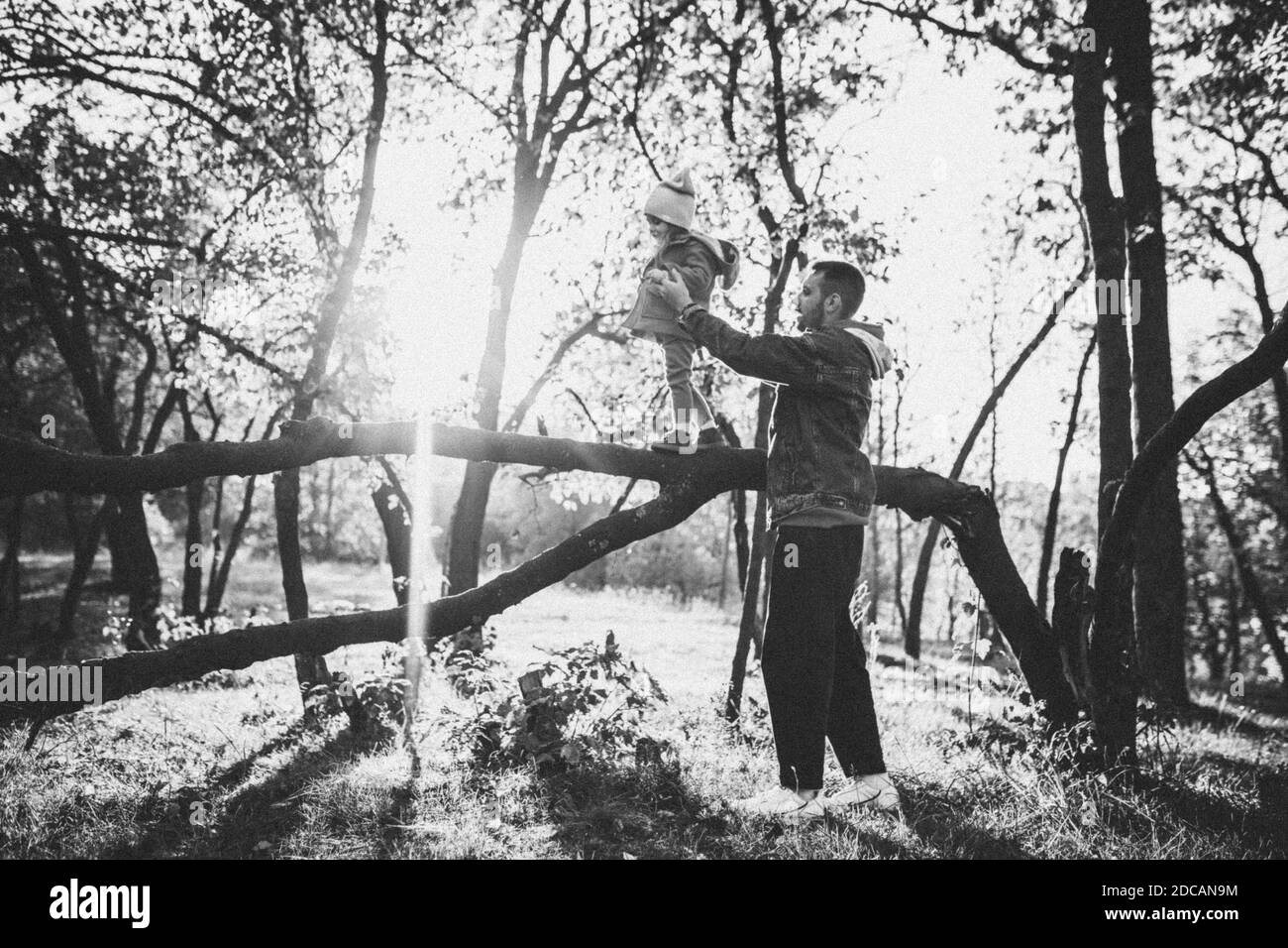 Noir et blanc. Père heureux et petite fille mignonne marchant sur le chemin de la forêt en automne ensoleillé jour. Temps de famille, togethterness, parent et concept d'enfance heureuse. Week-end avec des émotions sincères. Banque D'Images