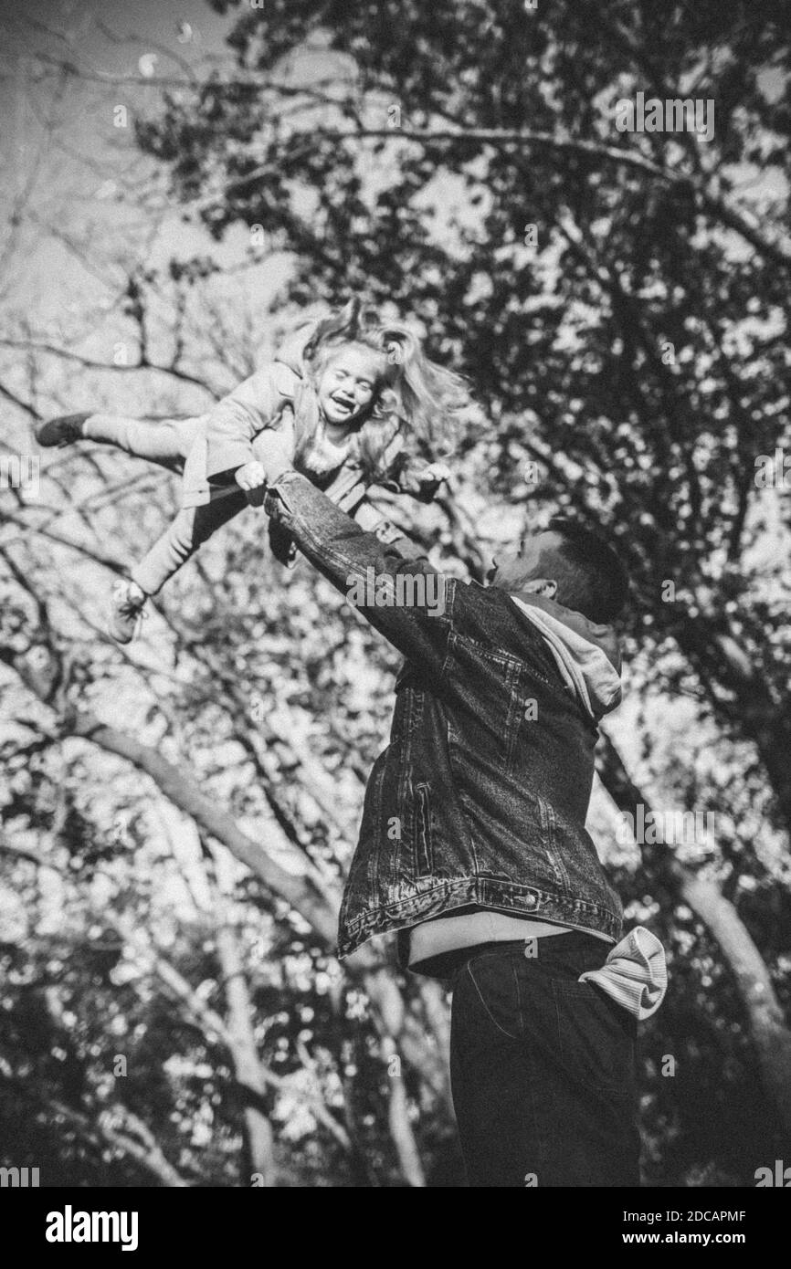 Noir et blanc. Père heureux et petite fille mignonne marchant sur le chemin de la forêt en automne ensoleillé jour. Temps de famille, togethterness, parent et concept d'enfance heureuse. Week-end avec des émotions sincères. Banque D'Images