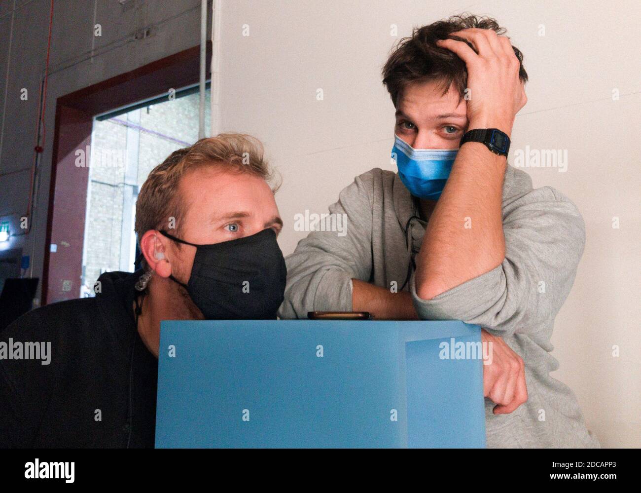 Deux jeunes hommes travaillent sur un film pendant la pandémie COVID-19 avec leurs masques, Londres, Royaume-Uni Banque D'Images
