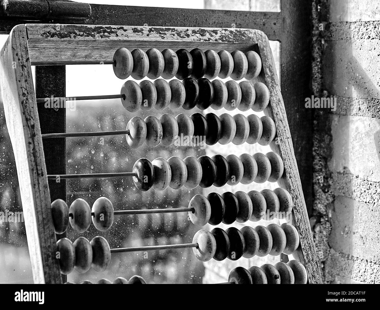 Photographie en noir et blanc d'un abacus couché contre une fenêtre. Banque D'Images