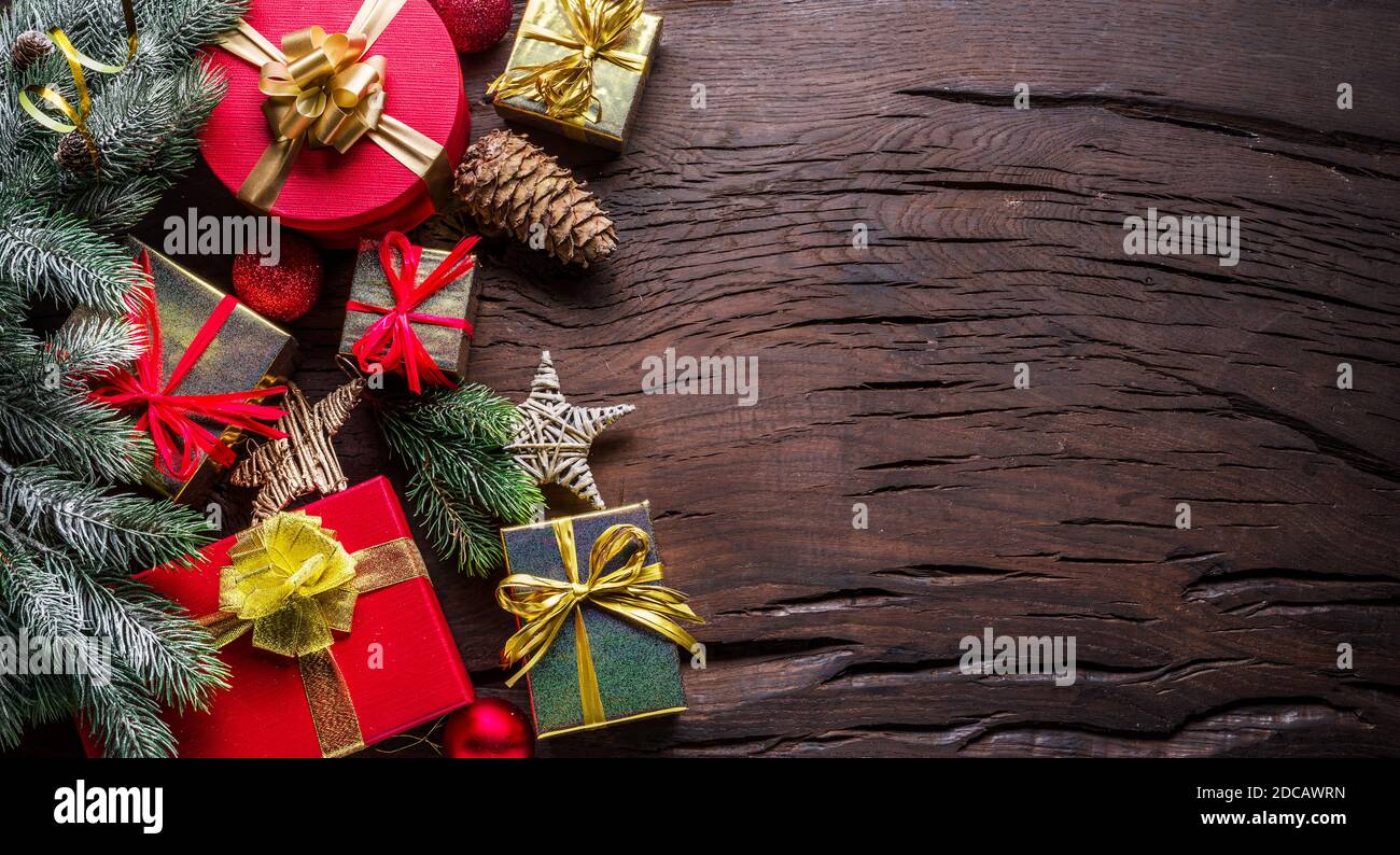 Décoration de Noël, boîtes cadeaux sur table en bois sombre. Le fond de Noël ou de vacances du nouvel an montre la magie des vacances de Noël. Vue de dessus. Banque D'Images
