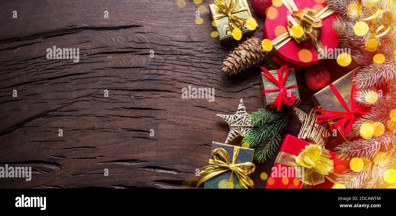 Décoration de Noël, boîtes cadeaux et lumières floues sur une ancienne table en bois. Le fond de Noël ou de vacances du nouvel an montre la magie des vacances de Noël Banque D'Images