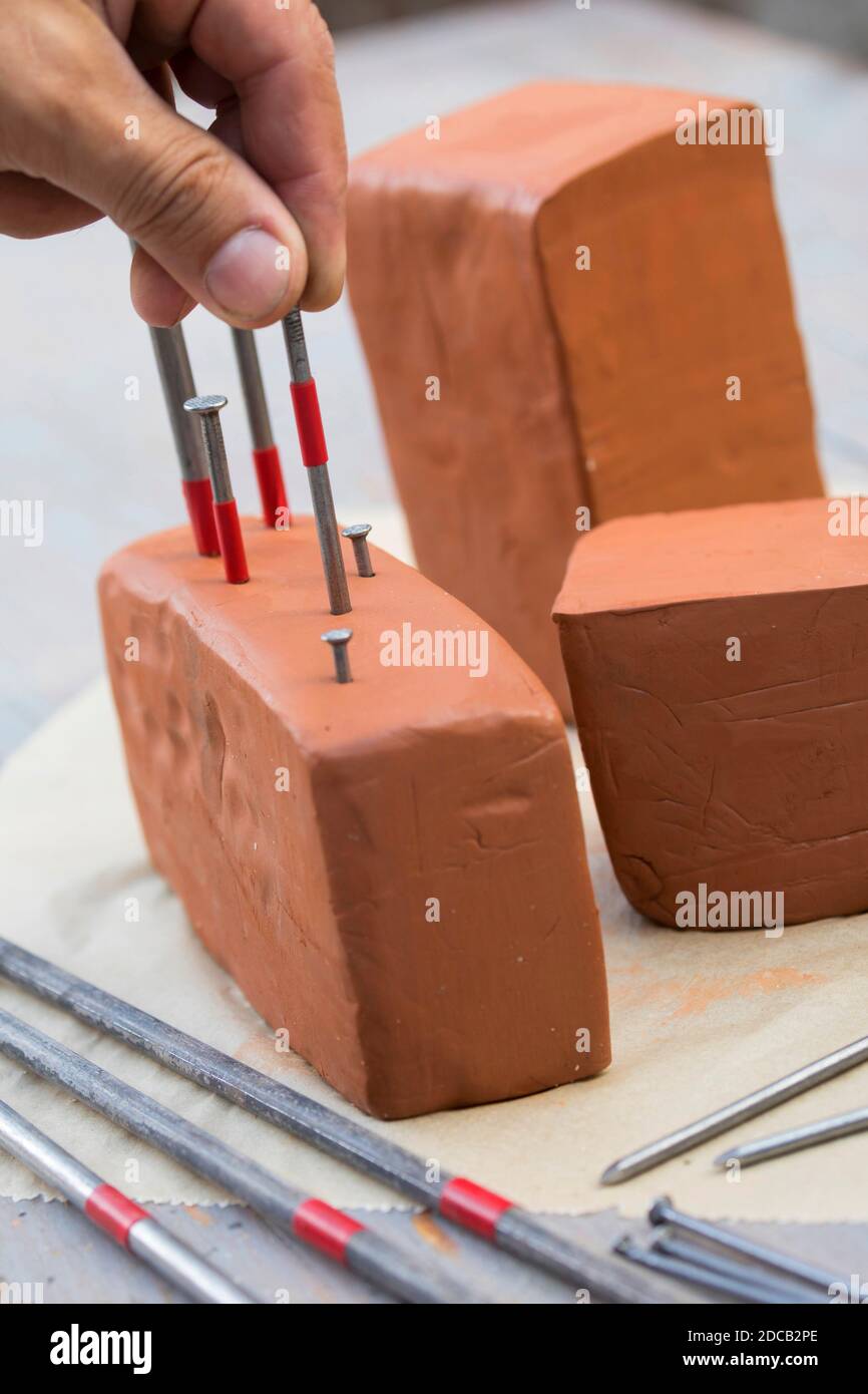 La boîte d'abeilles est faite de blocs d'argile, avec différents clous ar fait des trous de différentes tailles, série image 6/13, Allemagne Banque D'Images