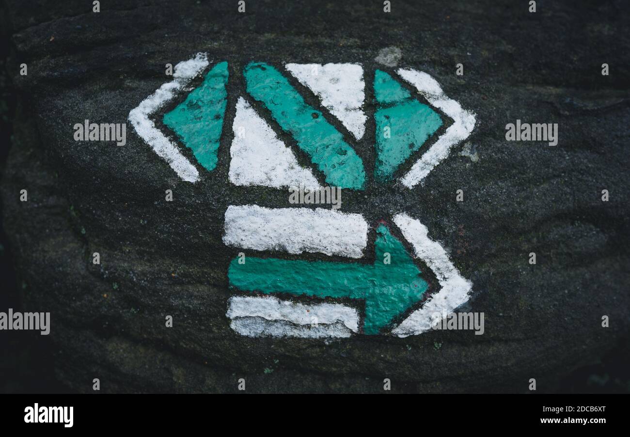 Panneau de randonnée sur un rocher. Un panneau qui trace un sentier de randonnée. Panneau touristique vert. Signes qui déterminent le chemin, en particulier dans le grès rocheux. Marche Banque D'Images