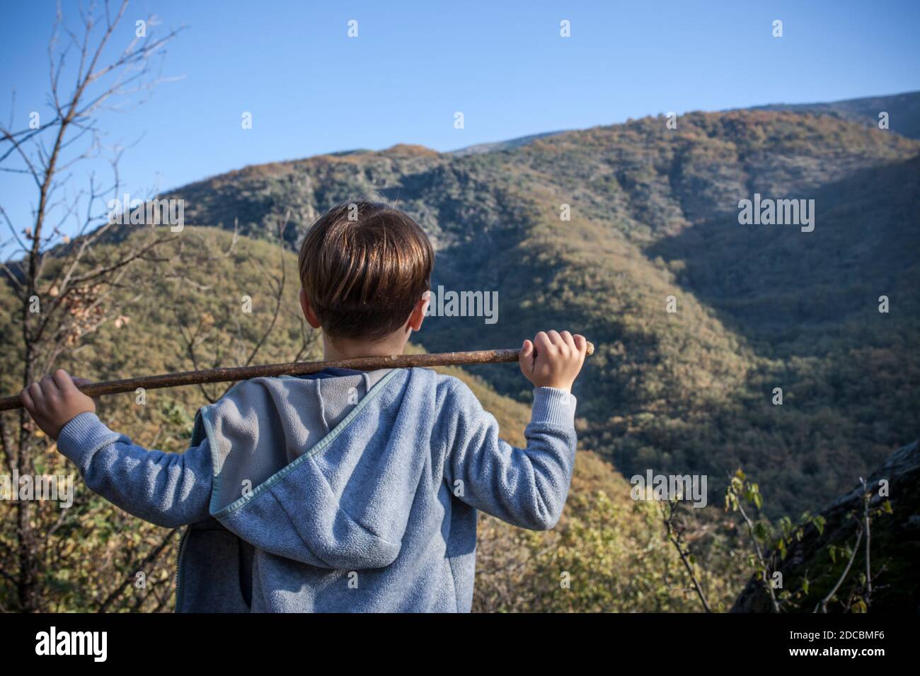 Enfant garçon observant la cascade de Chorrero de la Virgen à la Réserve naturelle Garganta de los Infiernos, Extremadura, Espagne. Il tient une canne sur son sho Banque D'Images