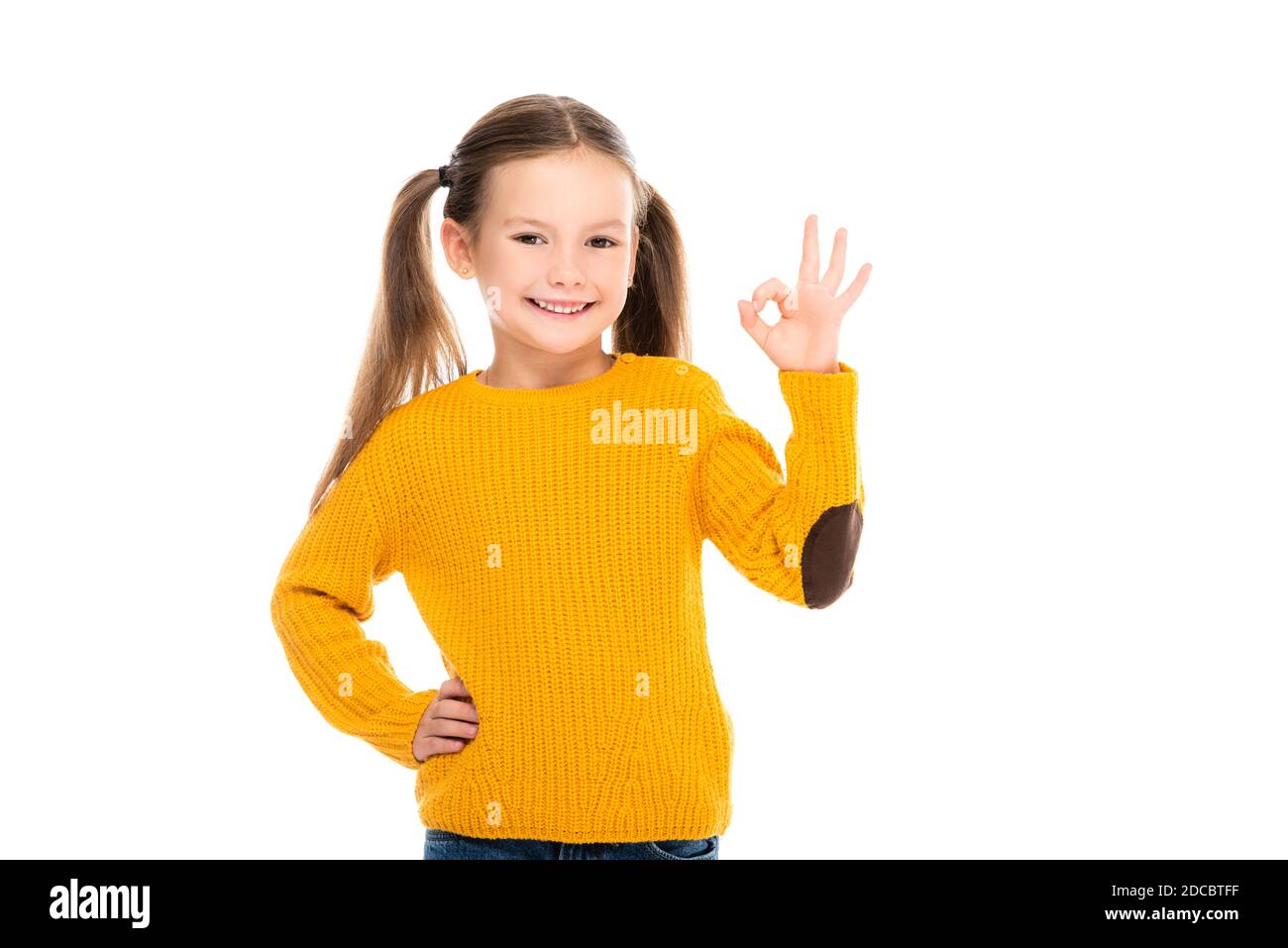 Fille souriante avec main sur la hanche montrant bien isolé sur blanc Banque D'Images