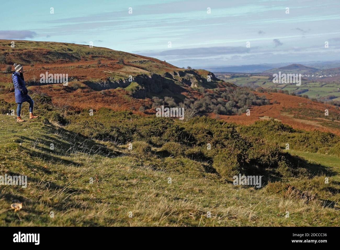 Une femme se tient dans le paysage sur la montagne Llangattock dans les Brecon Beacons, Powys South Wales, paysage d'automne au soleil le 5 novembre 202 Banque D'Images