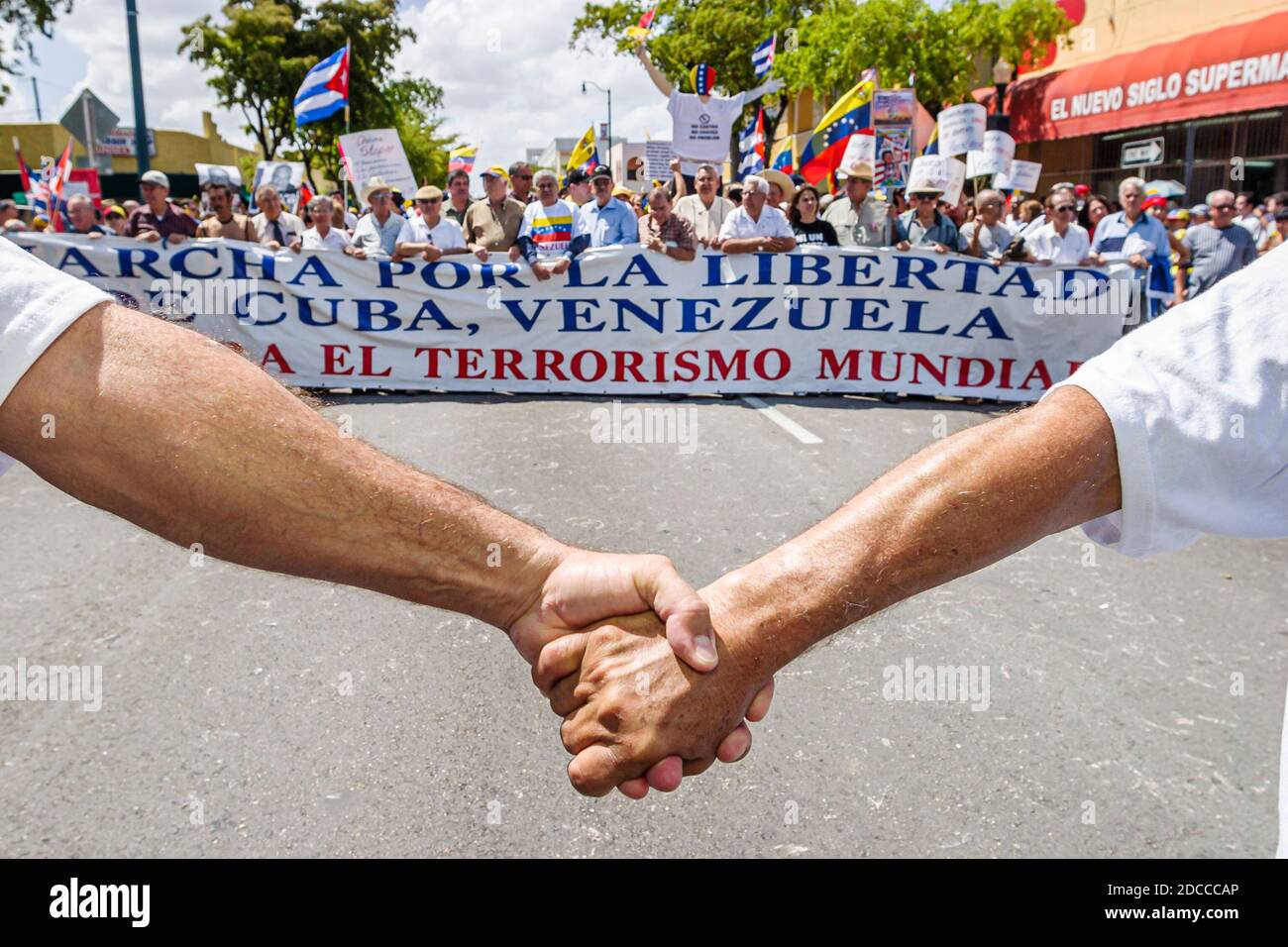 Miami Florida,Little Havana,hommes hispaniques,Calle Ocho protestation politique Fidel Castro Hugo Chavez,signe des bannières marchant les Vénézuéliens Cubains,tenant h Banque D'Images