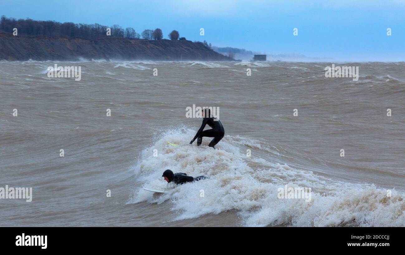 Paddle surf dans des conditions de tempête extrême avec des vagues élevées, Port Stanley Ontario Canada sur la rive nord du lac Érié. Banque D'Images