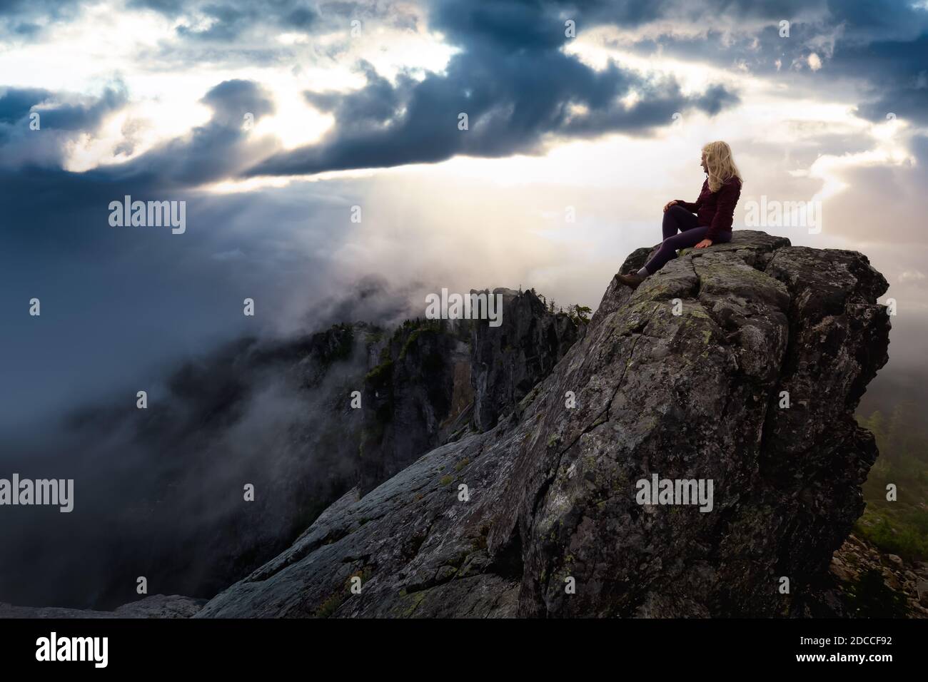 Une fille aventureuse au sommet d'une montagne Banque D'Images