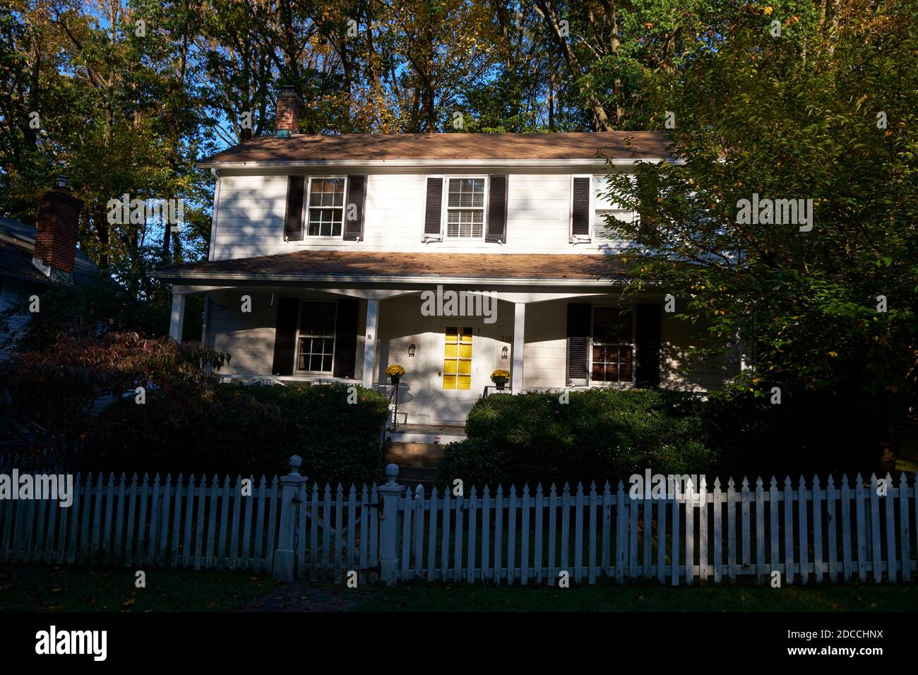 Clôture de piquets blancs et maison dans une rue de Dickeyville, la ville historique de moulin de l'époque coloniale. À Baltimore, Maryland, en automne. Banque D'Images