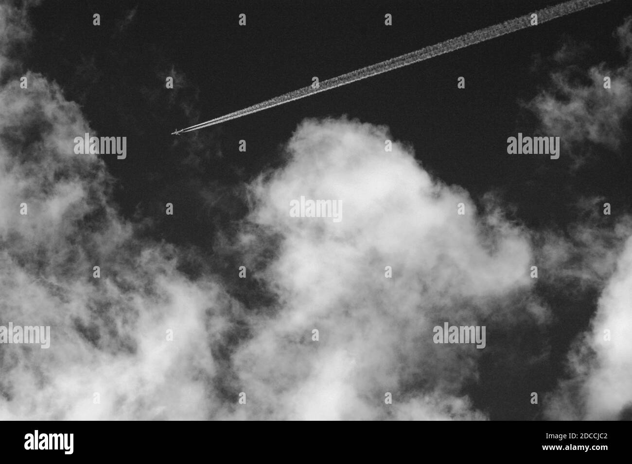 Un avion à réaction commercial laisse un sentier de vapeur, ou contrail, dans son sillage alors qu'il vole au-dessus du sud-ouest américain. Banque D'Images