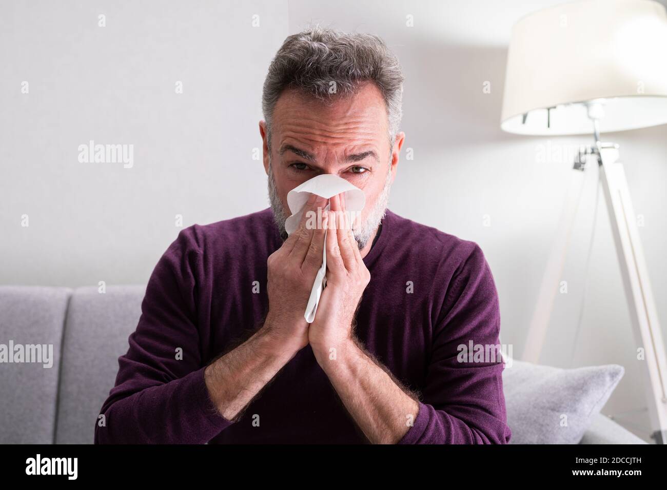 Aîné homme âgé malade à la maison éternuant Banque D'Images