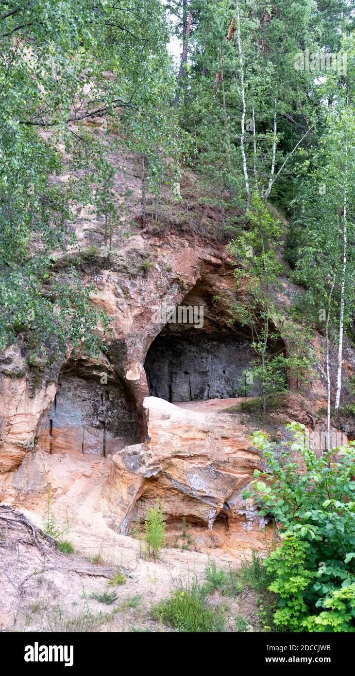 Grottes de grès à Ligatne, Lettonie. Vue sur la grotte de Lustuzis (Lustūzis) sur la rive de la rivière Ligatne. Grottes avec anciennes portes en bois. Banque D'Images