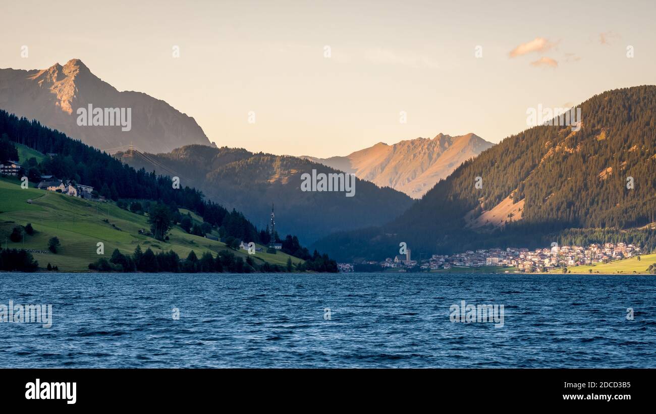 Coucher de soleil sur le lac Resia (allemand: Reschensee) et le village Resia à Val Venosta (Alto Adige, Italie). Il se trouve à côté du lac della Muta, en allemand: Haidersee Banque D'Images