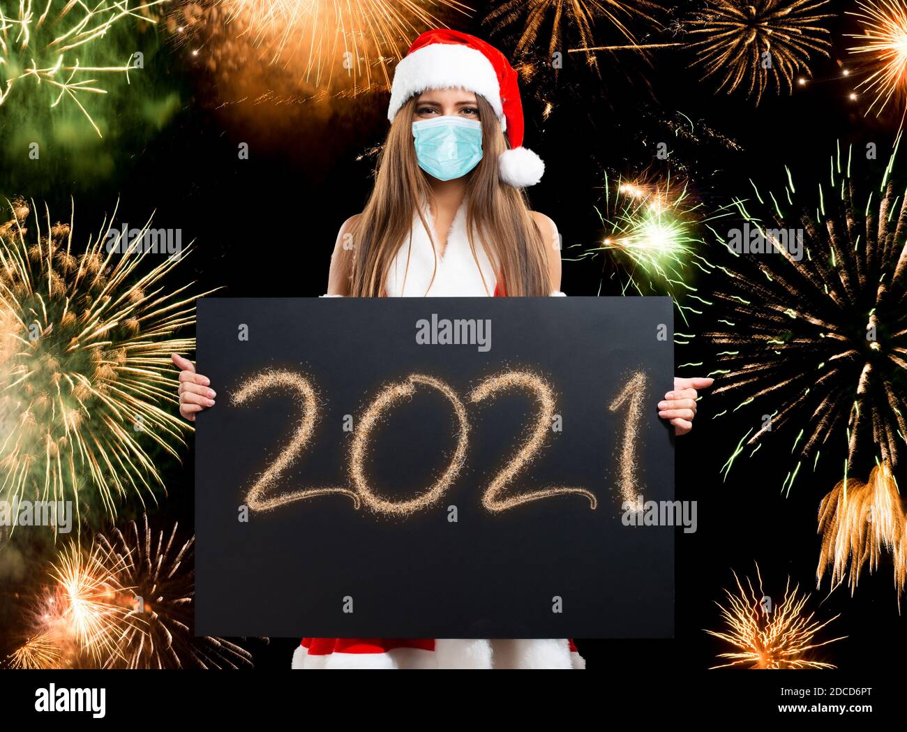 Concept de Noël et du nouvel an, femme tenant une carte de voeux heureux 2021 tout en portant un masque covid coronavirus Banque D'Images