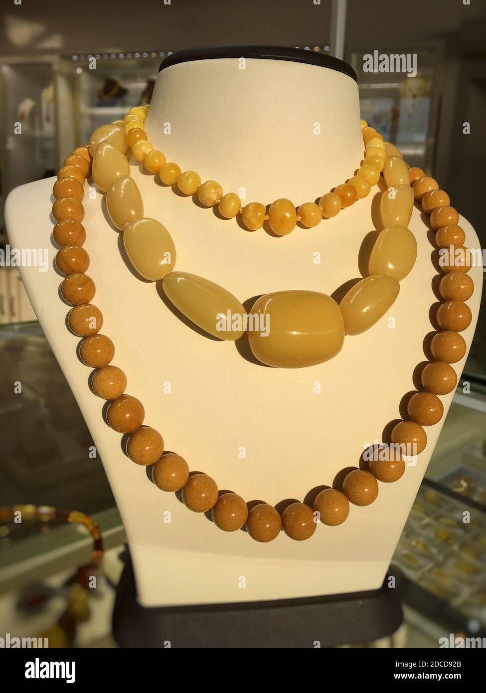 Perles de grande ambre Baltique blanc sur un support à bijoux. Banque D'Images
