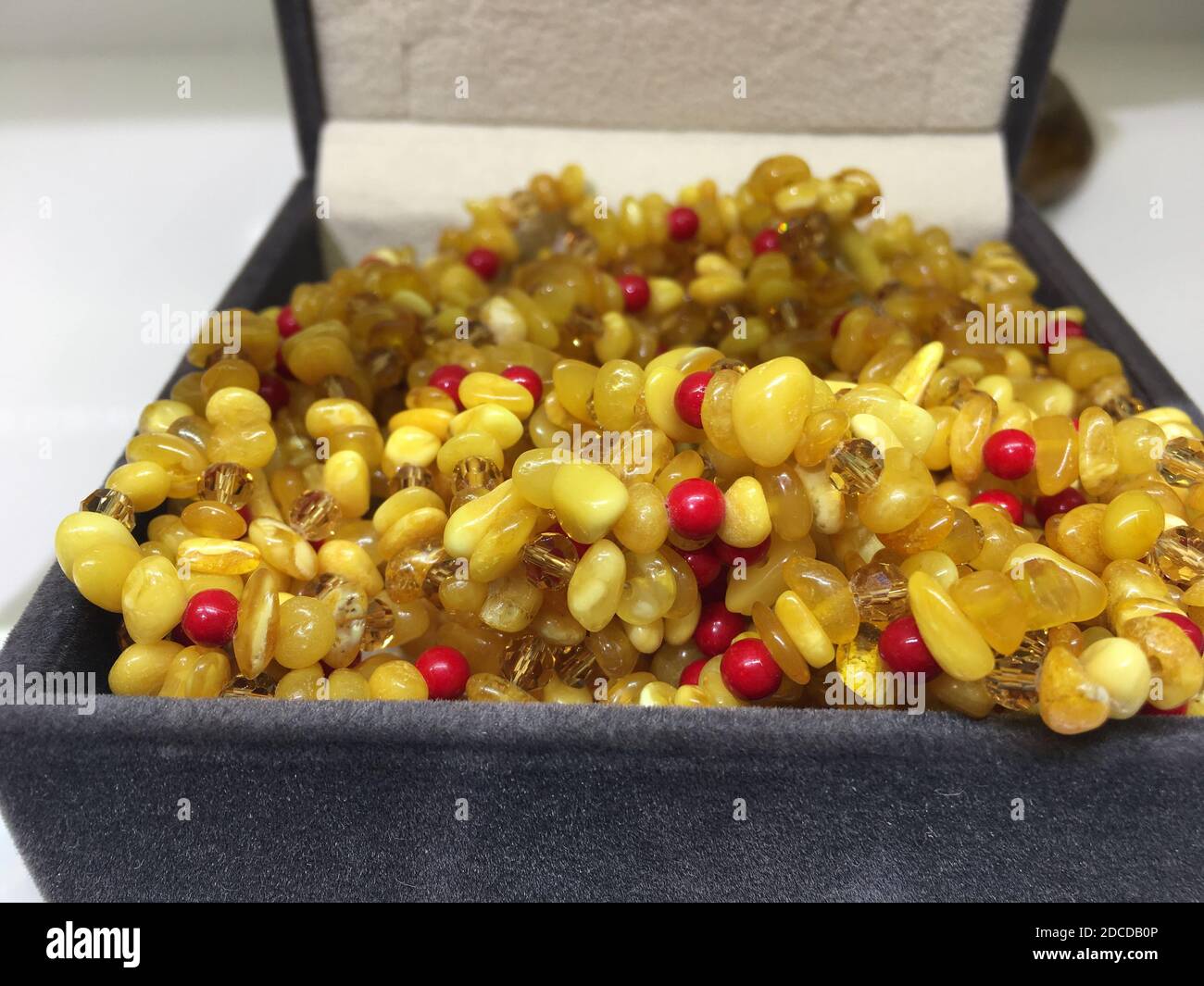 Collier en perles d'ambre dans une boîte à bijoux brune ouverte. Banque D'Images