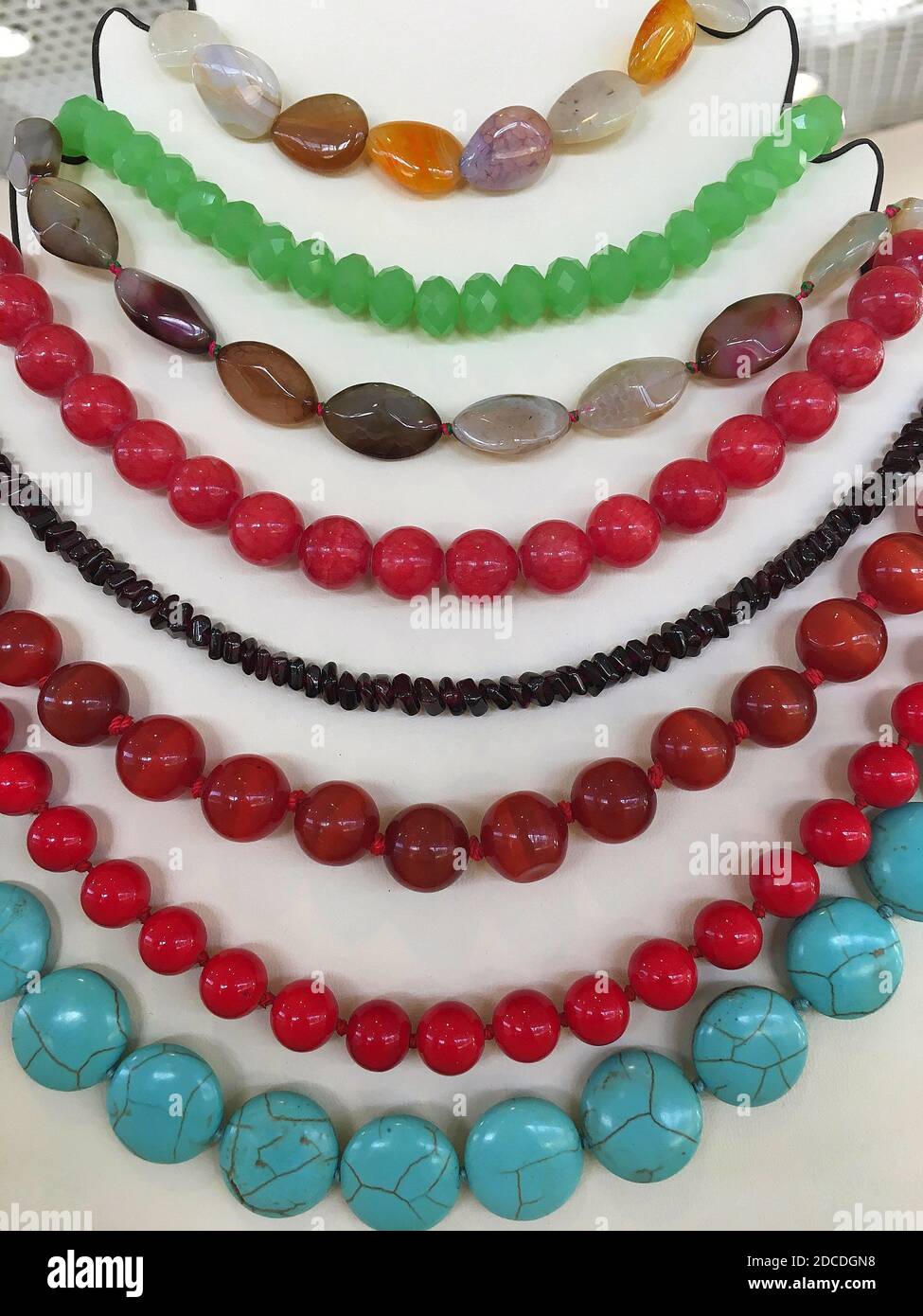 Perles de pierres précieuses multicolores sur un support à bijoux. Banque D'Images