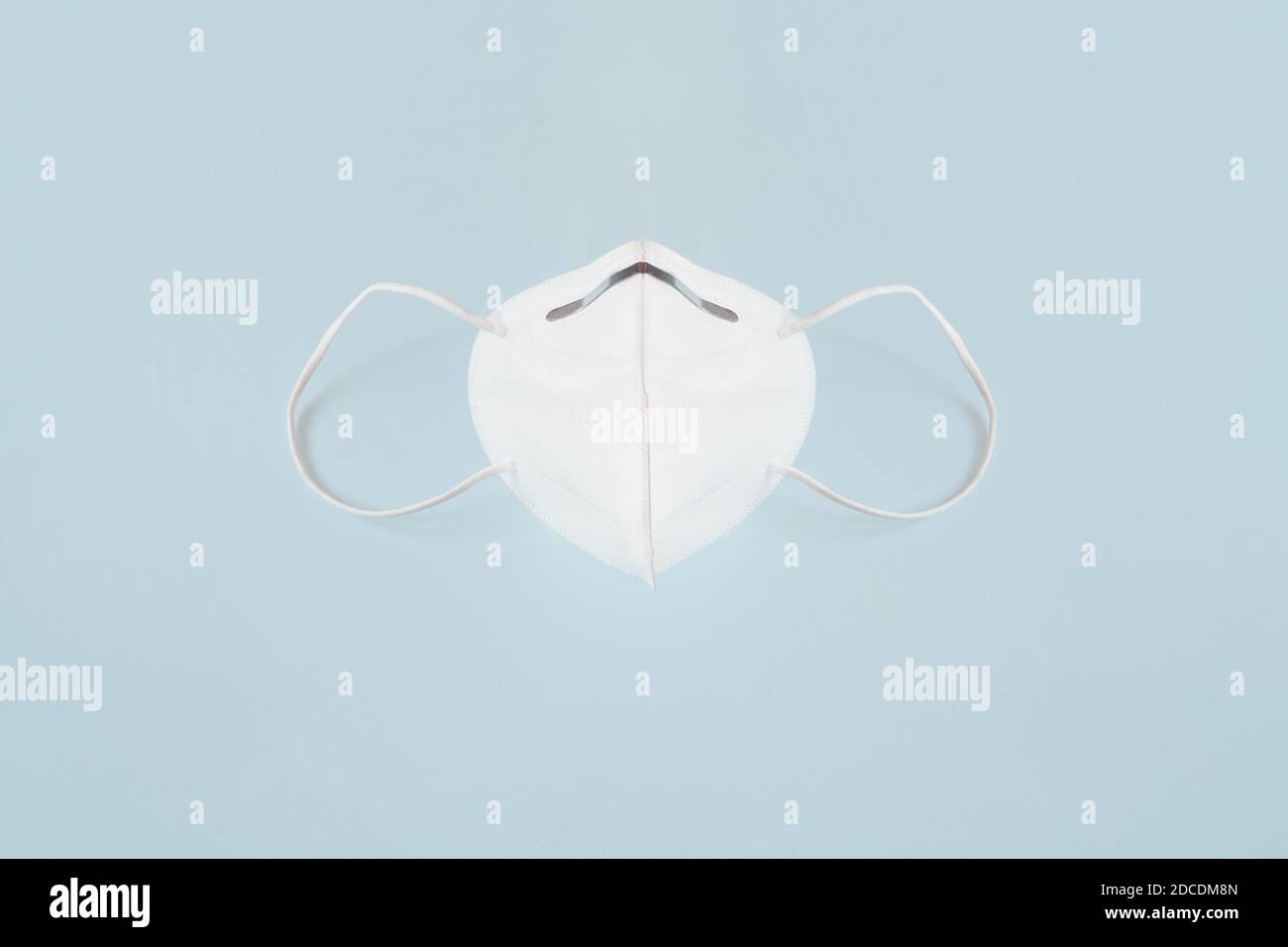 Masque chirurgical de protection Kn95 sur le bureau. Équipement de protection sur fond bleu texturé. Banque D'Images