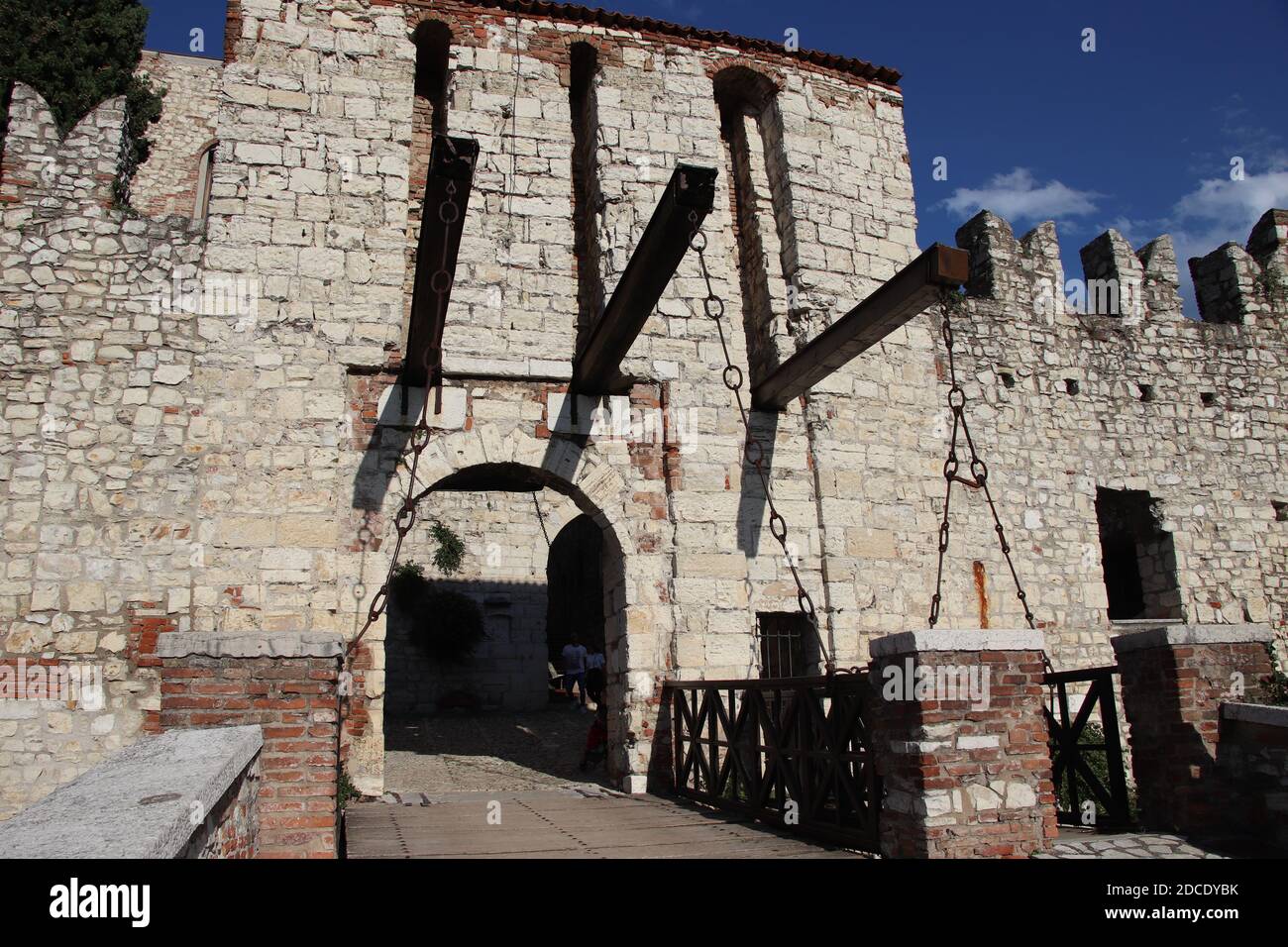 Mur en pierre avec merlons et porte de pont-levis du château médiéval de Brescia dans le nord de l'Italie Banque D'Images