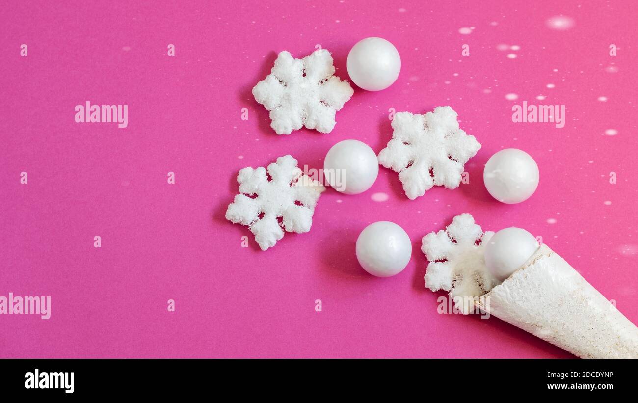 Cône gaufré blanc avec flocons de neige et boules décoratifs doux sur fond de papier rose. Joli motif carte pour Noël ou n'importe quel but. Banque D'Images