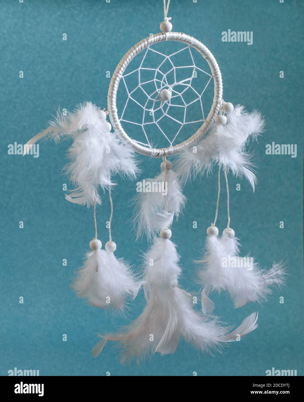 Magnifique roue magique blanche Dreamcatcher avec des plumes sur fond bleu. Amulette ethnique d'origine américaine, indienne et intérieure moderne d Banque D'Images