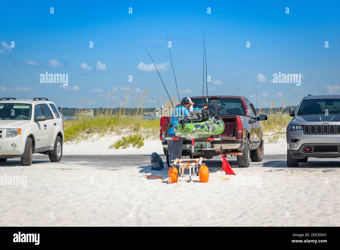 homme avec équipement de pêche et petit bateau sur remorque derrière 4x4 garés sur la plage à Biloxi Mississippi USA Banque D'Images