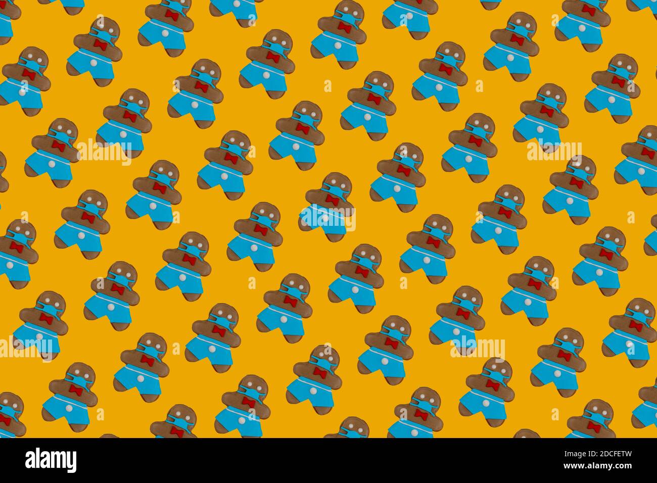 Pain d'épice homme n un masque médical. Biscuits sur fond jaune. Gâteries et cadeaux traditionnels pour Noël et les vacances du nouvel an. Banque D'Images