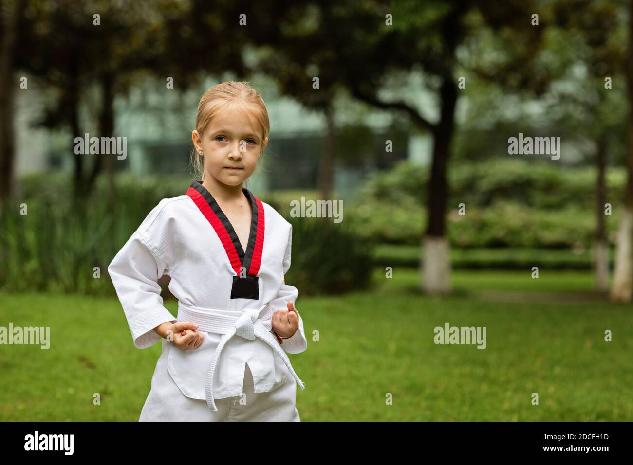 Petite fille caucasienne de six ans dans un kimono avec ceinture blanche  exerçant Taekwondo au parc d'été seul pendant le verrouillage du  coronavirus covid-19, soi-même Photo Stock - Alamy