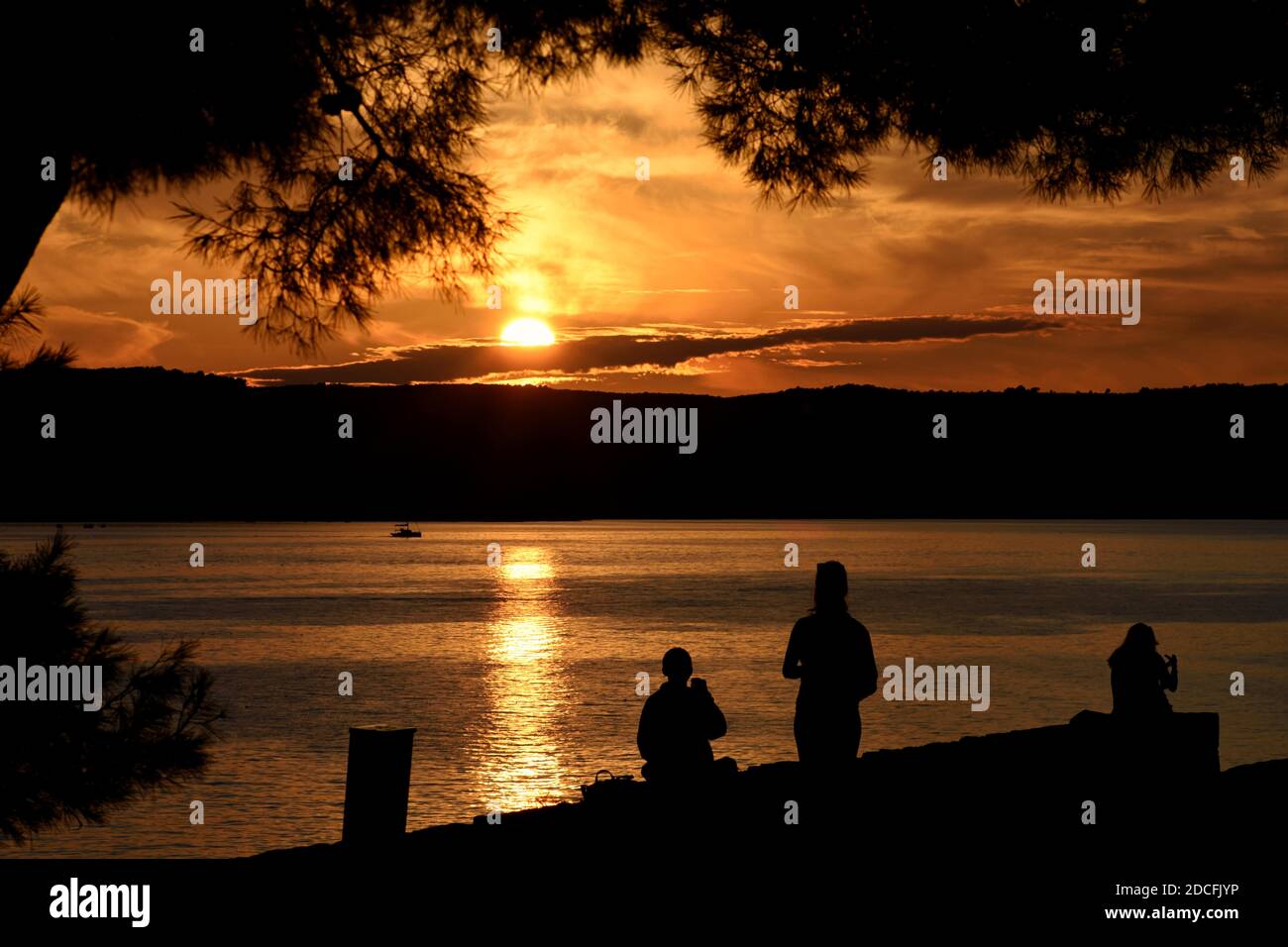 Silhouettes de personnes sur la plage, avec vue sur le coucher de soleil Le concept de la mer/méditation Banque D'Images