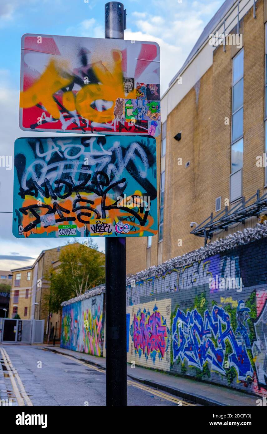 Panneaux routiers et murs couverts de graffiti à Gray Eagle Street, Shoreditch, East London, Royaume-Uni Banque D'Images