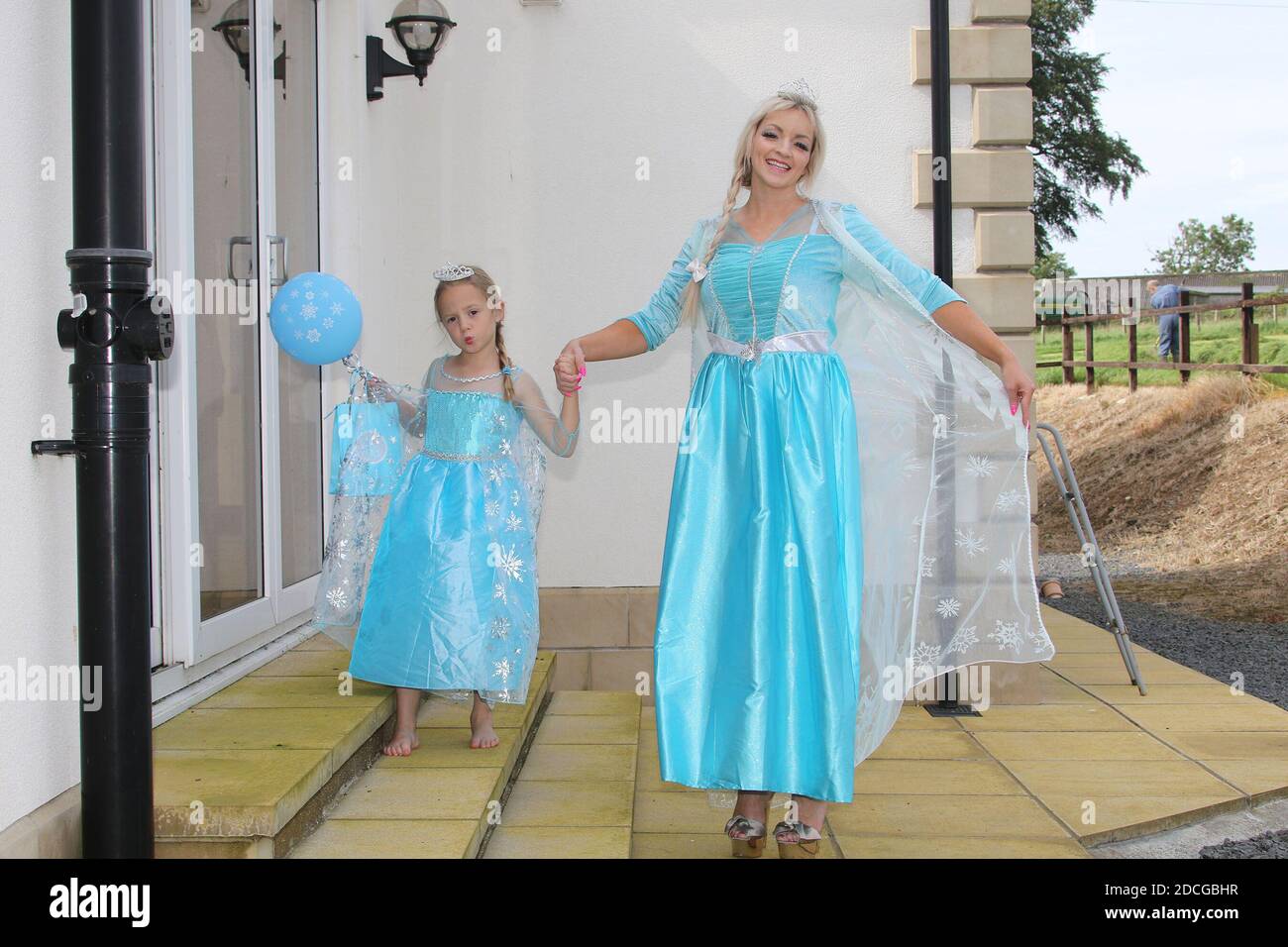 Déguisement fantaisie personnages de robe. Femme habillée comme Elsa de la  Reine des neiges avec une petite fille habillée comme une princesse Photo  Stock - Alamy