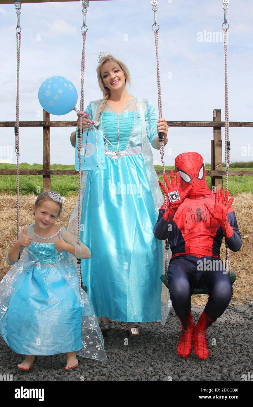 Déguisement fantaisie personnages de robe, Elsa, petite princesse, et  Spiderman sur balançoire dans le jardin Photo Stock - Alamy