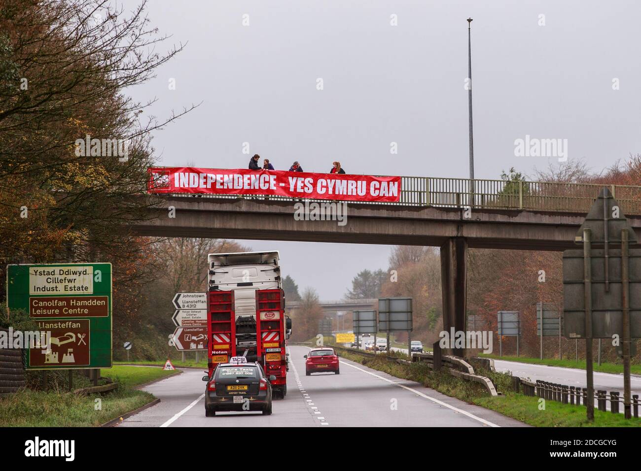 Carmarthen, Carmarthenshire, pays de Galles, Royaume-Uni. 21 novembre 2020. Les membres de Yes Cymru, le groupe de campagne pour un pays de Galles indépendant, volent des bannières sur un pont au-dessus de l'A40 en dehors de Carmarthen, Carmarthenshire, pays de Galles de l'Ouest. Crédit : Gruffydd Ll. Thomas Banque D'Images