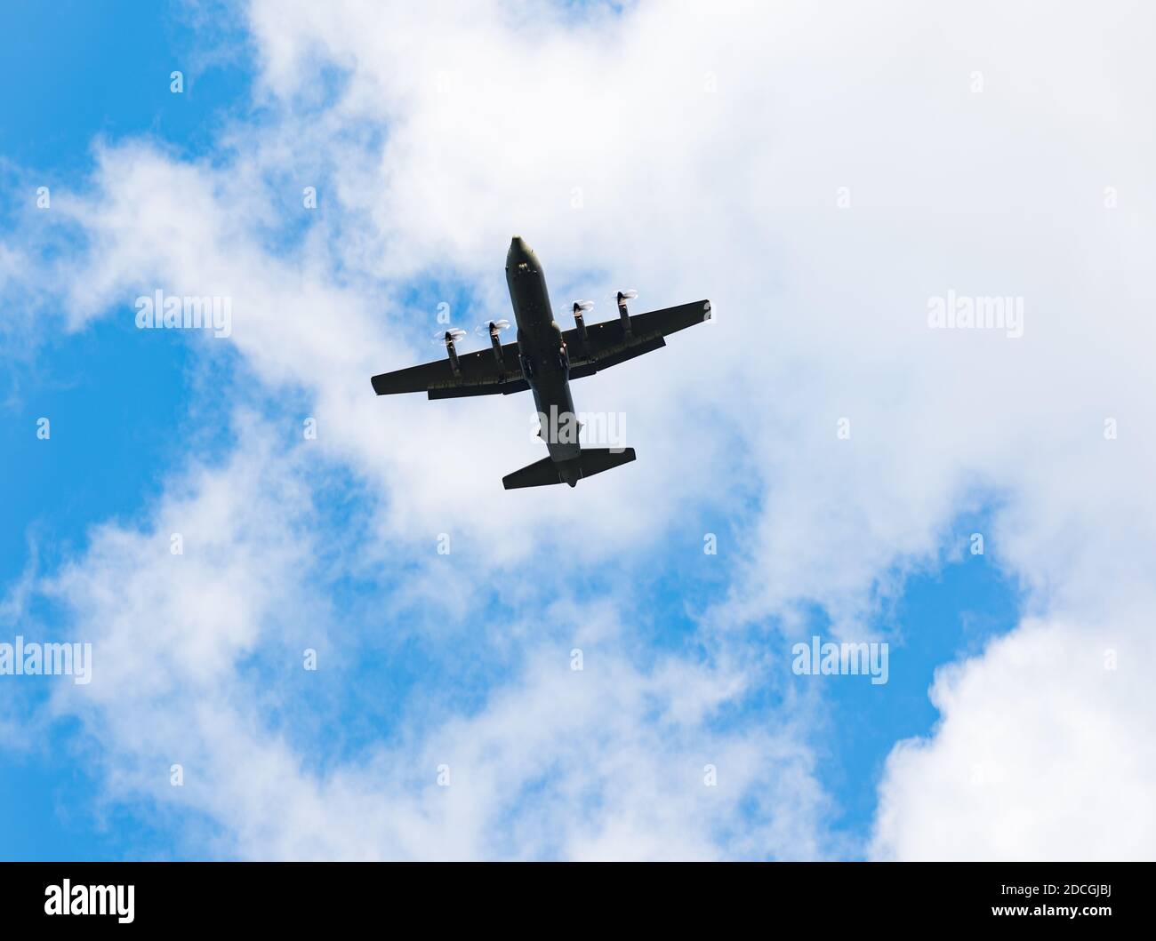 Avion de transport militaire au-dessus du ciel bleu et des nuages blancs Banque D'Images