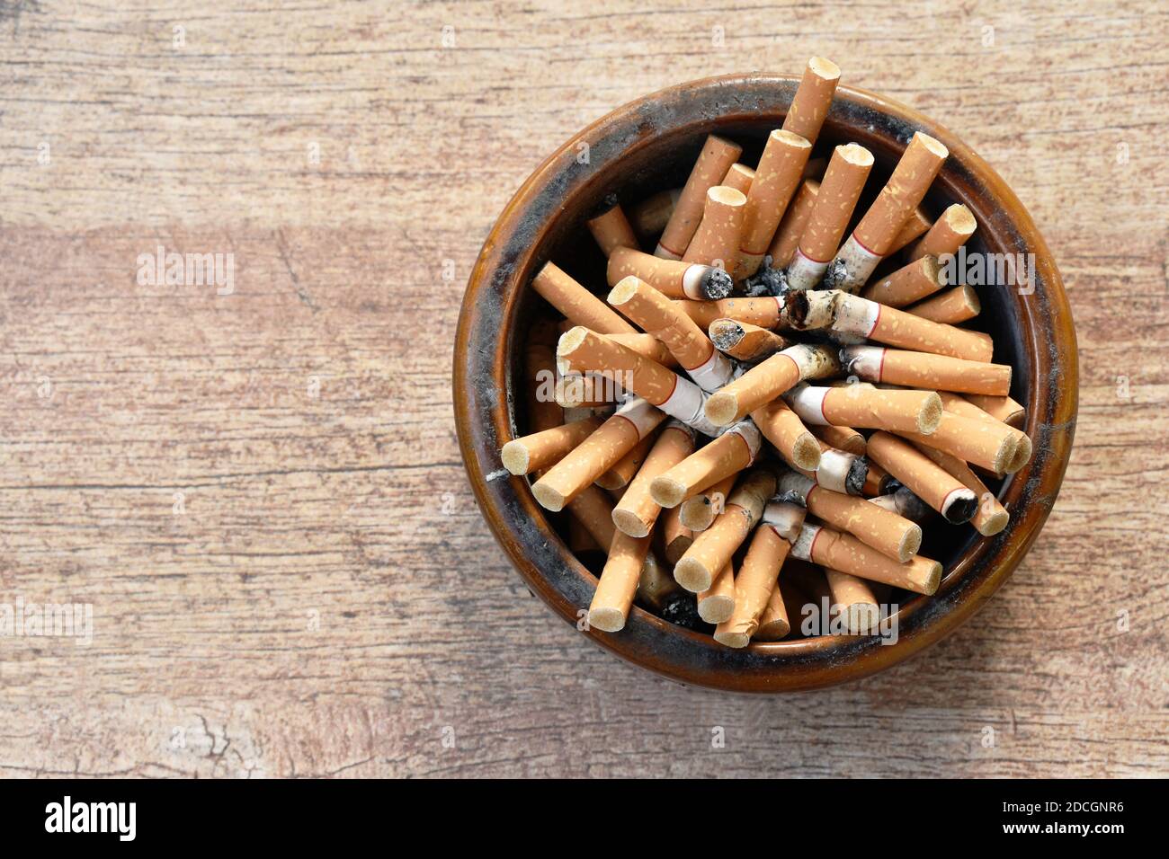 filtre à cigarettes en cendrier en céramique sur fond de bois Photo Stock -  Alamy