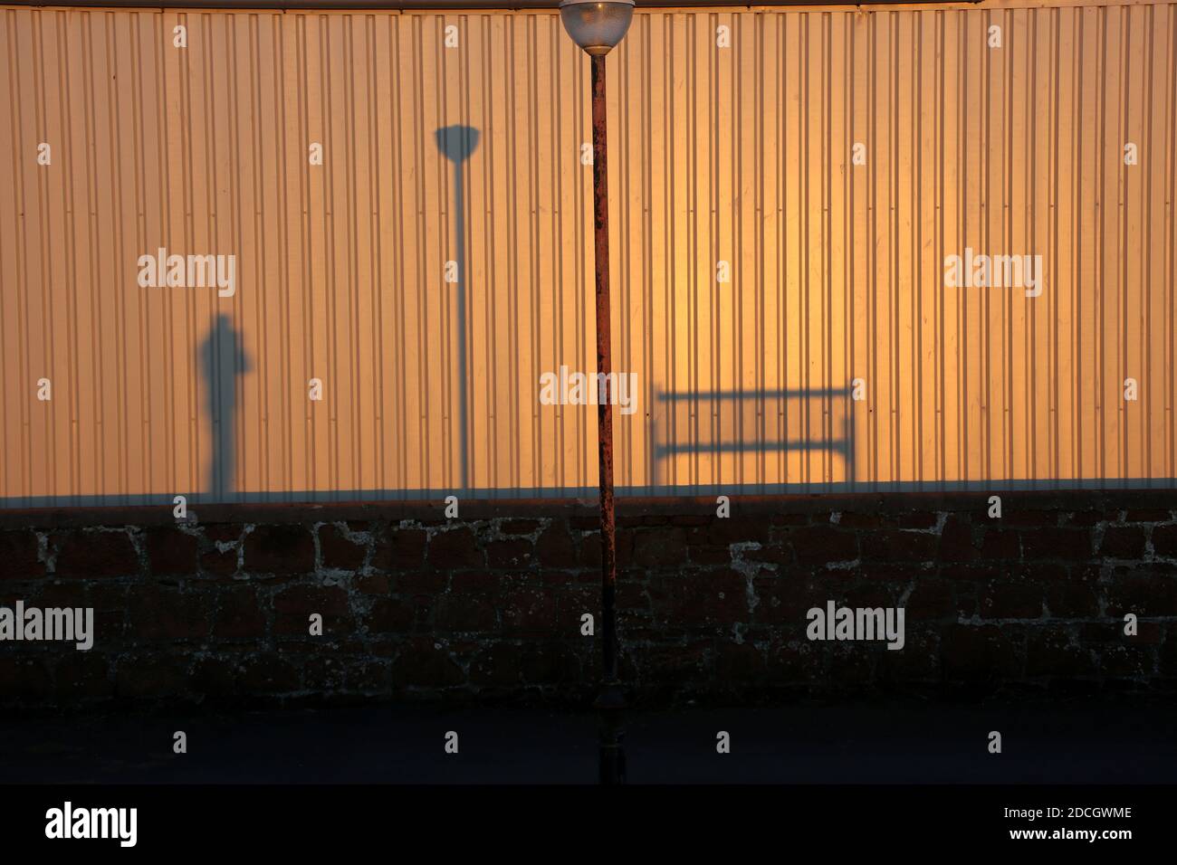 Ombres du banc, du lampost et du photographe sur un mur ondulé.Une image de conception .Espace pour le texte autour et dans la monnaie Banque D'Images